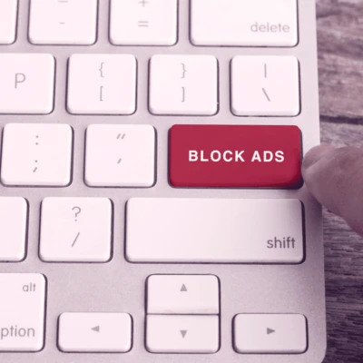 Egy kép a laptop enter billentyűjéről, amelyen az áll: BLOCK ADS. A prémium VPN'-nek a hirdetések és adathalász kísérletek blokkolására való képességének reprezentációja.