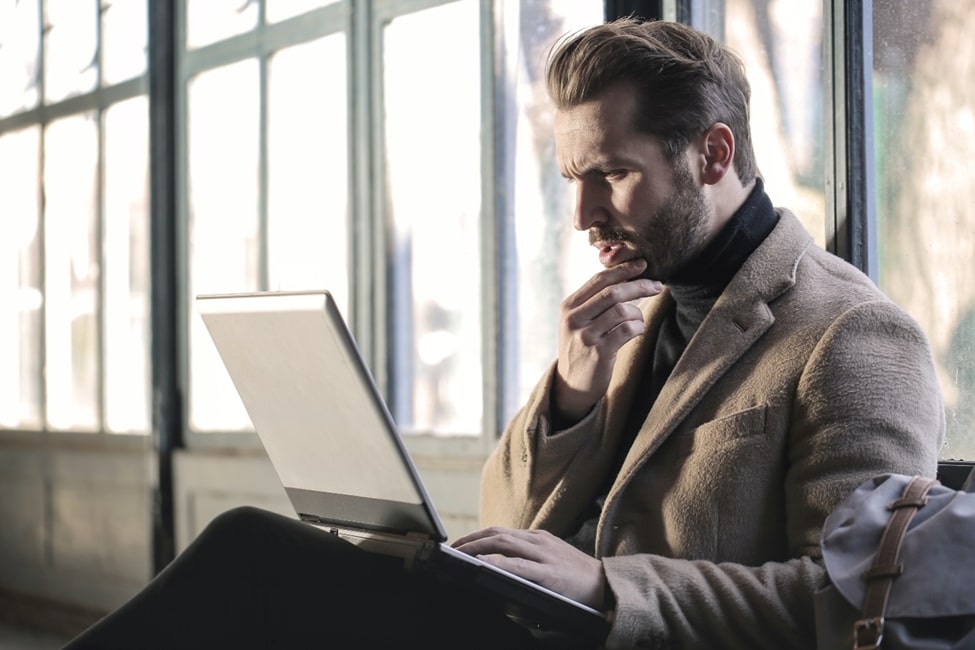 Man confusingly looking at his laptop about human factors in cybersecurity