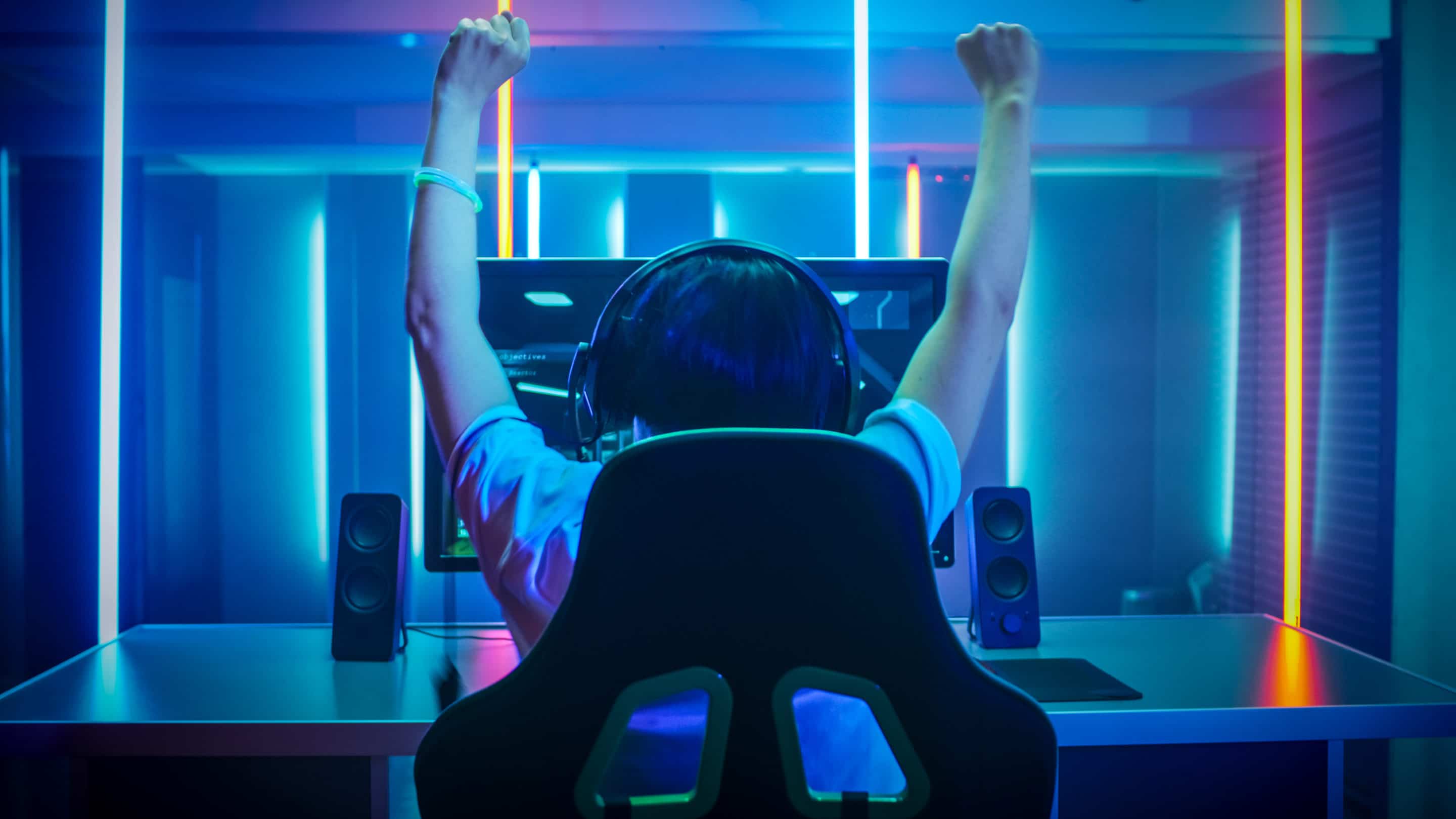 Gelukkige gamer zittend achter een computer