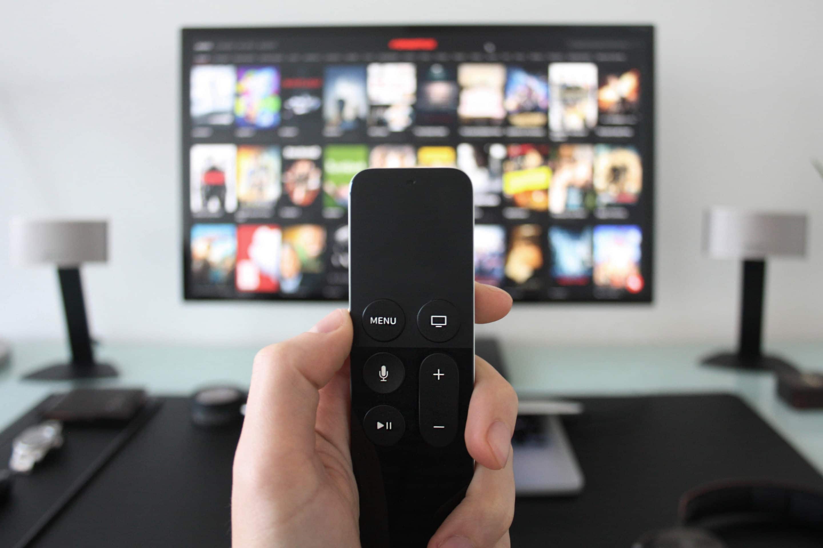 A person holding Apple TV remote